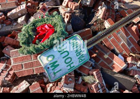 MAYFIELD, KENTUCKY - 20 DICEMBRE: Una corona di Natale e un cartello di parcheggio tra i detriti, il 20 dicembre 2021 a Mayfield, Kentucky. Numerosi tornado notturni hanno colpito diversi stati del Midwest il 10 dicembre, causando una distruzione diffusa e numerose vittime. Foto Stock