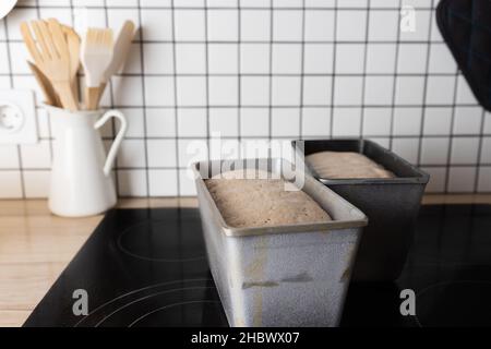Il processo di preparazione del pane di segale. L'impasto sul pane di segale viene deposto in uno stampo. Fine della lavorazione dell'impasto. Vista frontale. Foto Stock