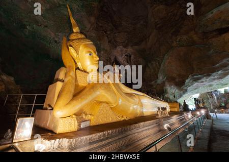 Statua d'oro del Buddha reclinante nella grotta del tempio di Wat Tham Suwankhuha a Phang Nga, Thailandia. Foto Stock