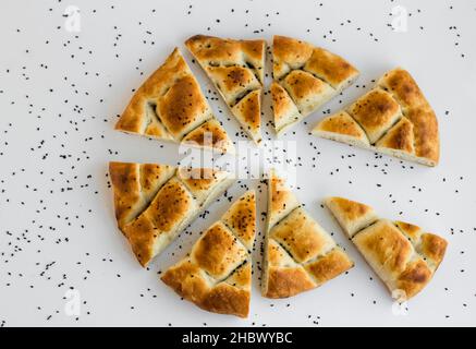 Pane Ramadan tagliato a fette triangolare, pide sullo sfondo bianco. Vista dall'alto. Foto Stock