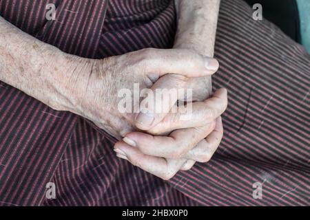 Mani aggrappate di vecchio Myanmar asiatico. Concetto di artrite reumatoide, osteoartrite o dolore articolare. Foto Stock