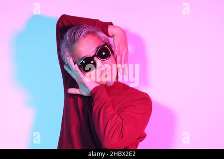L'uomo asiatico cool senior nella fotografia di colore gel luce. Foto Stock