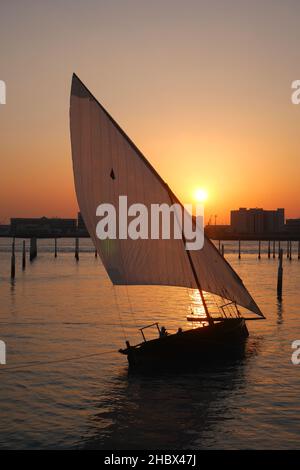 Sambuco a trafila nelle acque del Golfo Persico, al tramonto al Louvre, isola di Saadiyat, Abu Dhabi, Emirati Arabi Uniti Foto Stock