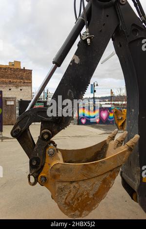 Una benna dell'escavatore in primo piano. Lavorare con l'escavatore in cantiere. Vista stradale, fuoco selettivo, nessuno Foto Stock