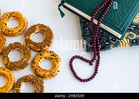 Tradizionale turco Sesamo anelli Kandil Simidi sulla superficie bianca con libro santo e rosario Foto Stock