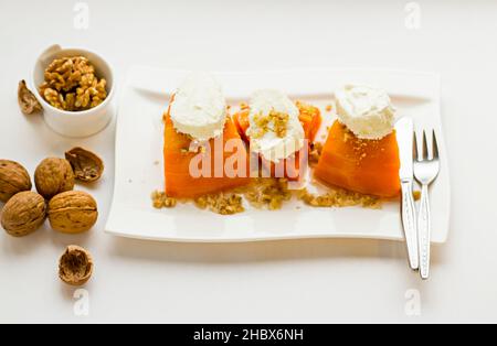 Tradizionale dessert turco di zucca, cremoso, kayak e noci tritate guarnendo in piatto con posate. Foto Stock