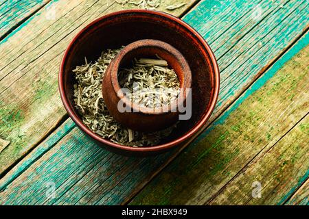 Legno di worm essiccato in una ciotola, erbe omeopatiche in medicina di erbe. Foto Stock