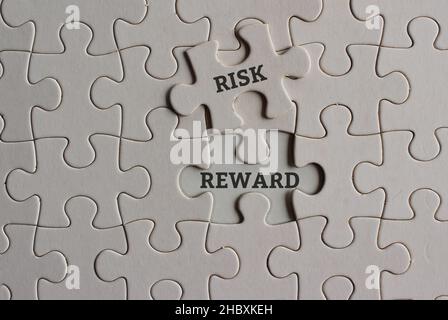 Concetto di business, rischio e ricompensa. Immagine vista dall'alto del puzzle con rischio di testo e RICOMPENSA. Foto Stock