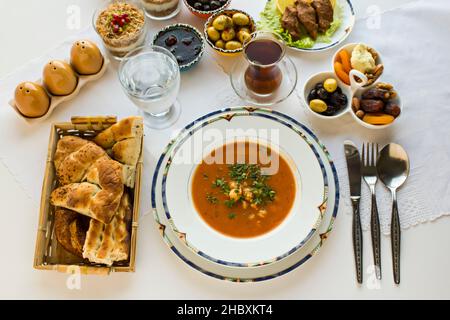 Tradizionale pasto turco Iftar con zuppa su superficie bianca. Vista dall'alto. Foto Stock