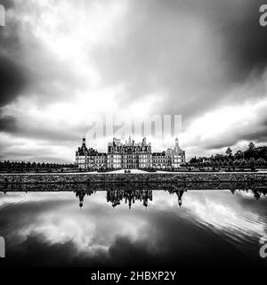 Vista grandangolare del Castello di Chambord nella valle della Loira, con i suoi giardini, giorno nuvoloso, riflessione d'acqua, Francia Foto Stock