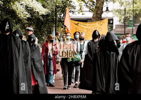 I manifestanti della ribellione animale vestiti come medici della peste con prego ascoltano la targhetta London 2020 Foto Stock