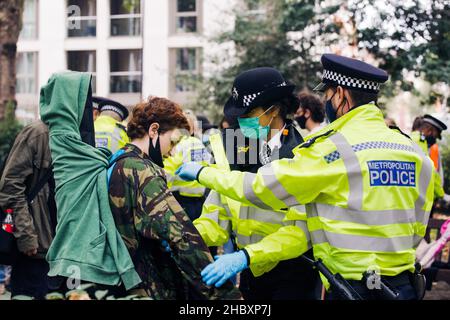 Ricerca di polizia Animal al Rebellion attivista a Londra 2020 Foto Stock