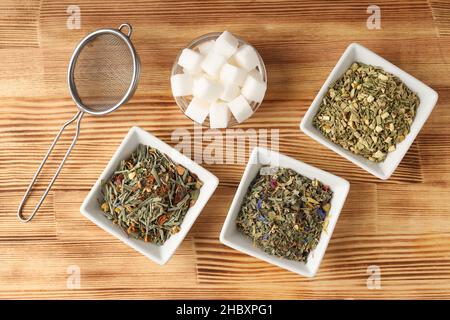 Concetto di cottura del tè con diversi tipi di tè su sfondo di legno Foto Stock