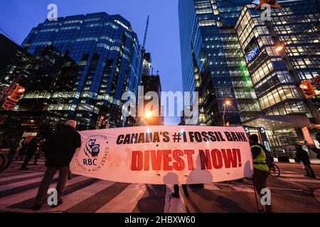 Toronto, Canada. 21st Dic 2021. Gli attivisti hanno in mano un banner dicendo: ìCanadaís #1 Fossil Bank, dismettere Now!î durante la manifestazione. I manifestanti si riuniscono al di fuori del centro RBC in solidarietà con Wetísuwetíen Land Defenders. Le loro richieste sono che RBC defunda il gasLink Coastal e rispetti la sovranità indigena. Credit: SOPA Images Limited/Alamy Live News Foto Stock