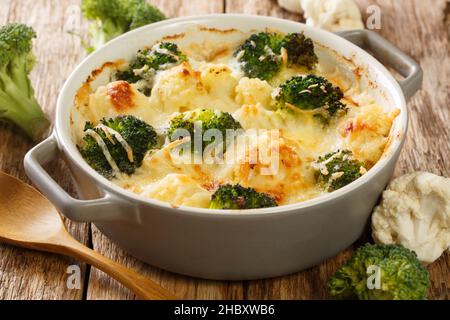 Casseruola Cauliflower e broccoli cotti al forno con salsa di formaggio in un primo piano pentola su un tavolo di legno. Orizzontale Foto Stock