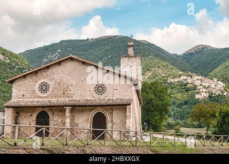 La chiesa di San Salvatore e il borgo montano Castelsantangelo sul Nera sullo sfondo, Regione Marche, Italia Foto Stock