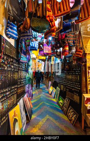 Stalla con gioielli e borse appesi su una strada stretta nei souk della medina, Fes, Marocco Foto Stock