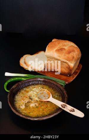 Zuppa gratuita di spaghetti di pollo in una ciotola di legno isolata sul nero Foto Stock