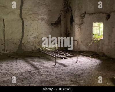 camera da letto abbandonata in una casa rovinata dopo un disastro naturale Foto Stock