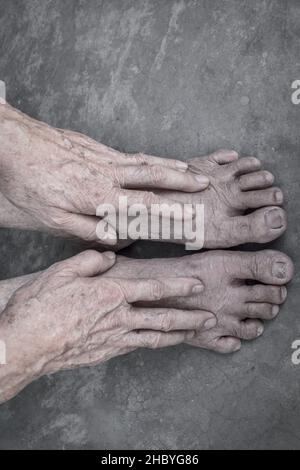 Mani e piedi dell'anziano asiatico. Concetto di salute e cura delle articolazioni, e l'invecchiamento della pelle. Isolato su sfondo concreto. Foto Stock