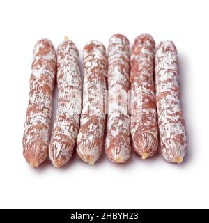 Fila di bastoncini di salame affumicati da vicino per uno spuntino isolato su sfondo bianco Foto Stock