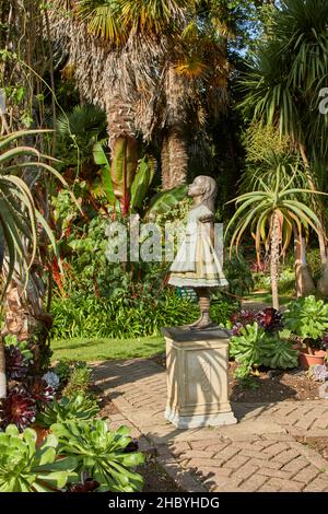 Statua di Alice nel paese delle meraviglie nei giardini subtropicali di Abbotsbury, un giardino di 18th secolo con piante rare ad Abbotsbury, Devon, Inghilterra sud-occidentale Foto Stock