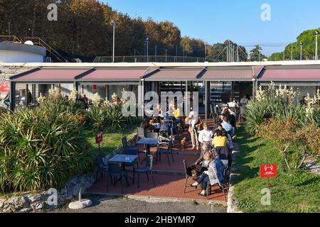 Vista ad alto angolo di un bar all'aperto con persone che gustano aperitivi in una giornata autunnale soleggiata, Genova, Albaro, Liguria, Italia Foto Stock