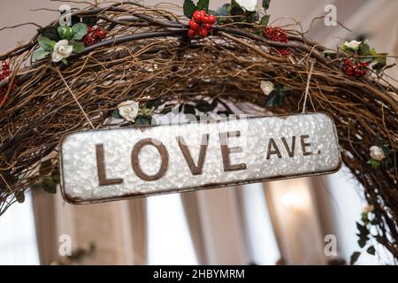 Love Avenue Ave diramazione a arco in legno con targa di metallo strada segno appeso sopra. Medicazione romantica cerimonia nuziale per la coppia in amore impegnato per essere Foto Stock