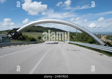 Il condotto che trasporta l'energia del vapore attraversa la strada, nei pressi di Larderello, Toscana, Italia Foto Stock