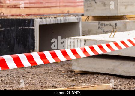 il nastro di sicurezza a strisce rosso e bianco protegge l'area pericolosa, messa a fuoco selettiva Foto Stock