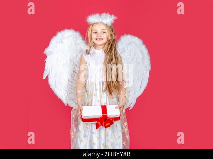 Angelo dei bambini con regalo. Piccolo angelo con ali bianche contiene il regalo. Ragazza angelica giocosa. Ragazza carina dell'angelo con le ali degli angeli Foto Stock