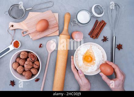 La vista dall'alto del luogo di lavoro dello chef prepara l'impasto per la torta. Ingredienti per cuocere sulla superficie grigia. Messa a fuoco selettiva. Foto Stock