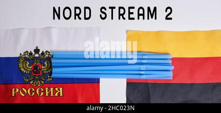 Cannucce in plastica su bandiere nazionali russe e tedesche. Gasdotto Nord Stream, sanzioni e politica. Russia contro Germania Foto Stock