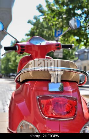Lato posteriore dello scooter rosso con luce di arresto posteriore. La moto è un veicolo e trasporto in città. Foto Stock