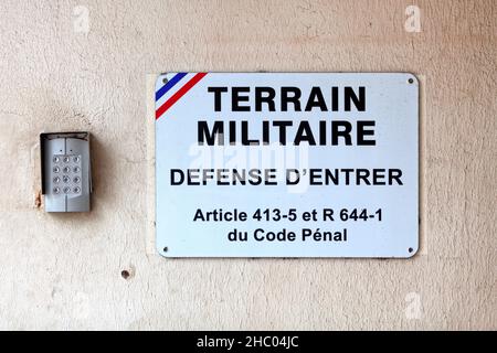 Un digicode e un cartello fuori dall'ingresso di una base militare francese che dice un francese 'terreno militare, défense d'entrer' Foto Stock