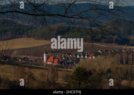 Kajov villaggio con grande chiesa con alta torre in inverno blu cielo giorno di colore Foto Stock