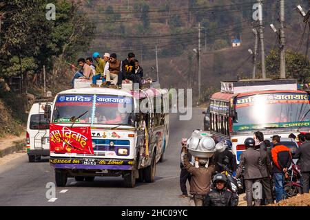 I passeggeri che viaggiano in cima a un autobus noleggiarono per una festa di nozze a Malekhu, Nepal. Foto Stock