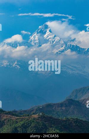 Machhapuchare o Fishtail nel Himal Annapurna, da Sarangkot Hill, Pokhara, Nepal. Un piccolo stupa si siede sul crinale di fronte. Foto Stock