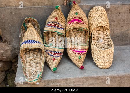 Coppie annidate di sandali nepalesi shu ya lakkan radizionali realizzati con paglia di riso e corda di iuta. In vendita a Bungamati, Nepal. Foto Stock