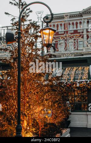 Albero di Natale dorato e lanterna ardente su strada decorata. Decorazione esterna di Capodanno Foto Stock