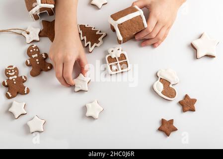 Casa di pan di zenzero nelle mani del bambino. Preparazione per il Natale. Vista dall'alto. Foto Stock