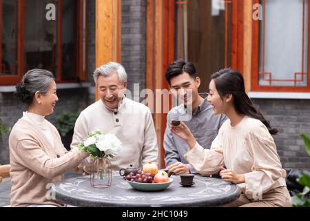 Famiglie felici che bevono il tè e chiacchierano nel cortile Foto Stock