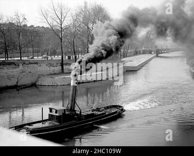 Paris la chiatta fumosa della Senna a Pont de la Concorde, 1945. Fumi di scarico da un rimorchio che sta tirando fuori-de-vista le chiatte di trasporto. Pont Alexandre III e la Torre Eiffel sono intraveduti sullo sfondo. Foto Stock