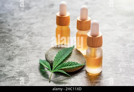 CBD o THC full spectrum Medical Cannabis Oils on stone table with Hemp leaf copy space Foto Stock