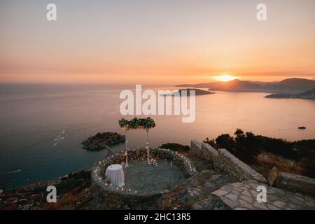 Arco di nozze sulla terrazza panoramica che si affaccia sull'isola di Sveti Stefan al tramonto Foto Stock