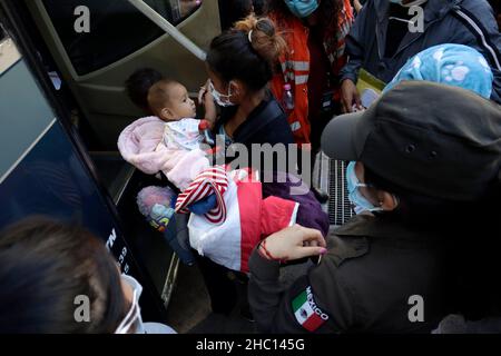 I migranti dell'America centrale salono a bordo dell'autobus che si dirige verso il nord del paese alla ricerca di opportunità di lavoro dopo 10 giorni di permanenza nella Casa del Pellegrino. Il 22 dicembre 2021 a Città del Messico, Messico. (Foto di Luis Barron/ Eyepix Group) Foto Stock