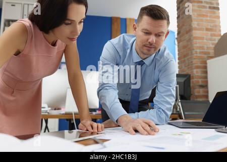 I lavoratori aziendali intelligenti impegnati esaminano i documenti statistici sul luogo di lavoro Foto Stock