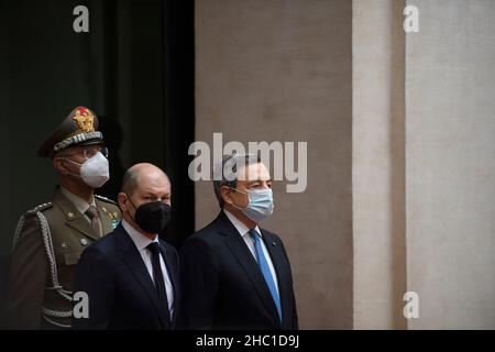 Roma, Italia. 20th Dic 2021. Il primo ministro italiano Mario Draghi (R) dà il benvenuto al cancelliere tedesco OLAF Scholz (C) a Roma, Italia, il 20 dicembre 2021. L'Italia e la Germania probabilmente avvicineranno le loro posizioni sul modo in cui esamineranno rispettivamente le regole fiscali dell'Unione europea, ha detto lunedì il primo ministro italiano Mario Draghi dopo il suo primo incontro con il nuovo cancelliere tedesco OLAF Scholz. Credit: Str/Xinhua/Alamy Live News Foto Stock