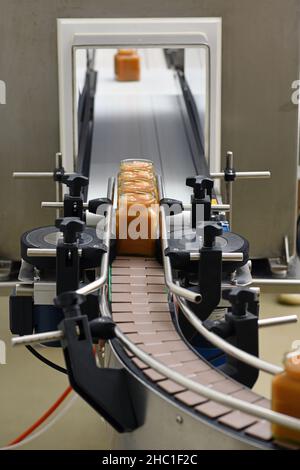 Vasetti di miele cremato in una linea di confezionamento presso una fabbrica commerciale di miele Foto Stock