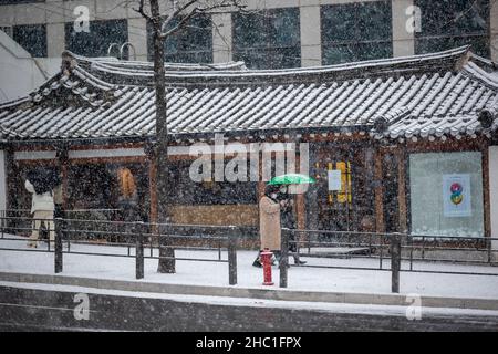 Seul, Corea del Sud. 18th Dic 2021. La gente cammina nella neve in una strada a Seoul, Corea del Sud, 18 dicembre 2021. Credit: Wang Yiliang/Xinhua/Alamy Live News Foto Stock